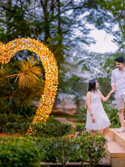 A romantic moment by a heart-shaped light installation. This is a perfect prop for capturing the love and joy of a pre-wedding shoot.