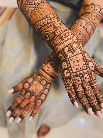 A beautiful shot of the 'Two States, One Heart' mehendi, showing the detailed work on both hands.