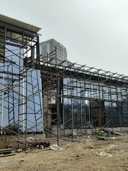 Another angle of the Experience Center construction, showing the juxtaposition of the solid and glass volumes.