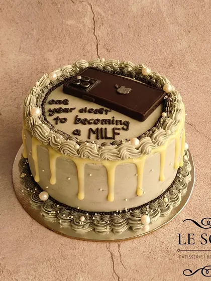 This cake was made during the iPhone 15 Pro Max frenzy. I love the vintage piping style combined with the modern, edible fondant iPhone on this 1 kg Chocolate Butterscotch cake.