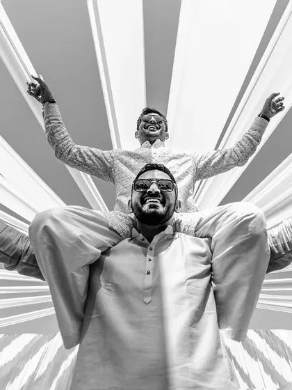The groom and his best man celebrating during the Baraat. This black and white shot captures pure energy and friendship.
