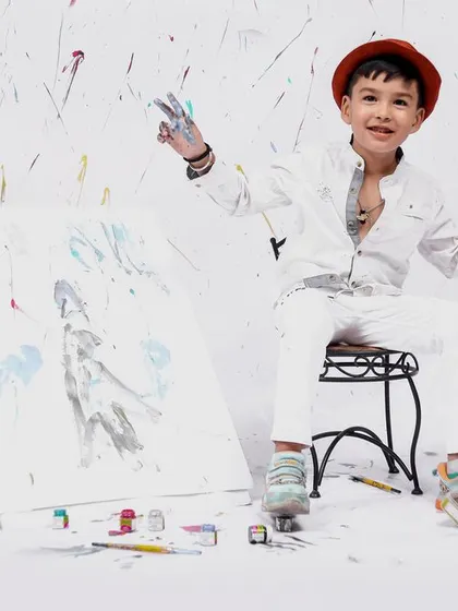 A candid moment from our painter-themed session, where the little artist is proudly showing off his colorful hands after a fun time painting.