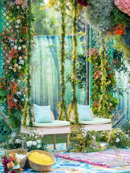 Another angle of the whimsical floral swing, showing the colorful patterned rug and baskets of flower petals for the ceremony.