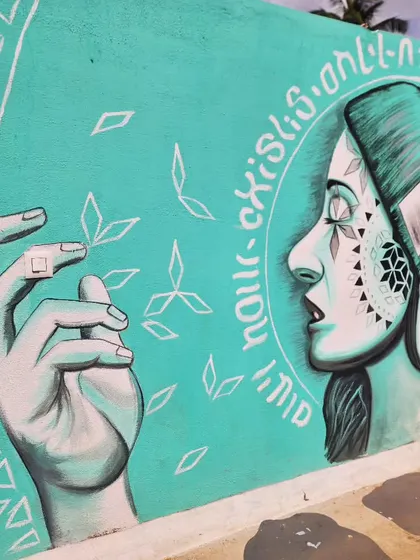 A close-up of the hands and face in the mural, highlighting the fine line work and geometric details.