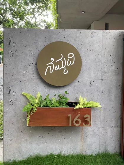 A close-up of the "Nemmadi" nameplate, crafted by Urban Texture. The design is simple, modern, and rooted in our local Kannada language.