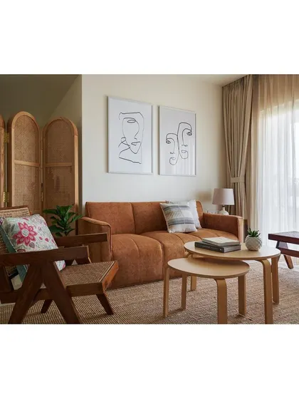 We designed this serene living room with bespoke furniture to create a cohesive and calming atmosphere. The space features our custom sofa, a handcrafted wooden armchair with cane detailing, and nesting coffee tables, all unified by a palette of warm, natural materials.