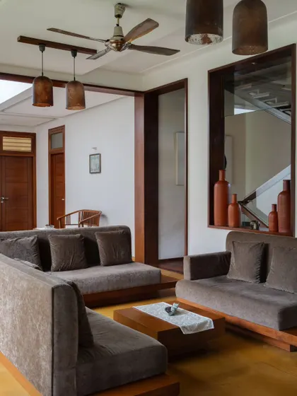 The formal living area features low-slung sofas and earthy tones, creating a comfortable and grounded space for conversation.