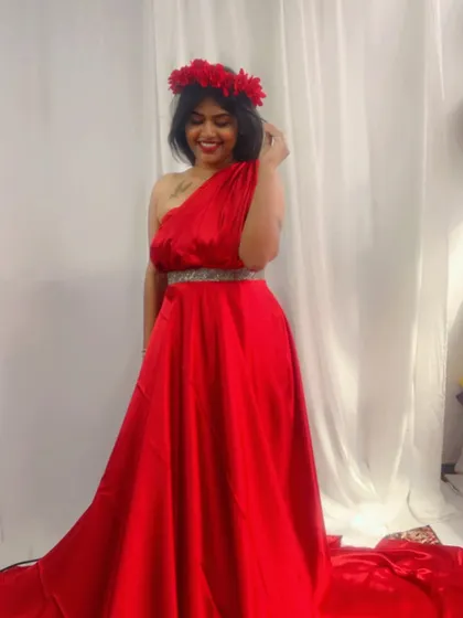 A closer look at the one-shoulder style of our red satin trail gown, available for rent.