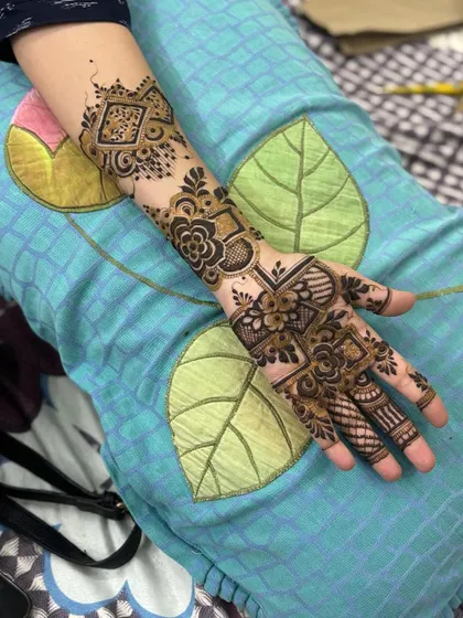 A full view of the geometric Arabic henna design on the arm.