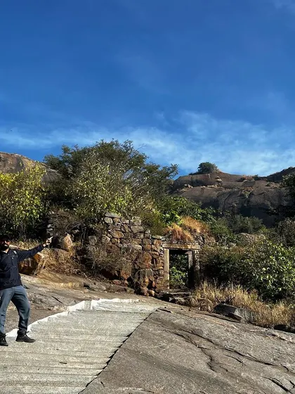 Pointing towards the path ahead on a mountain trail.