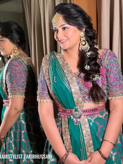 A side-swept bubble braid with delicate pearl and flower accessories. This is a soft and romantic look, ideal for a Mehendi or Sangeet ceremony.