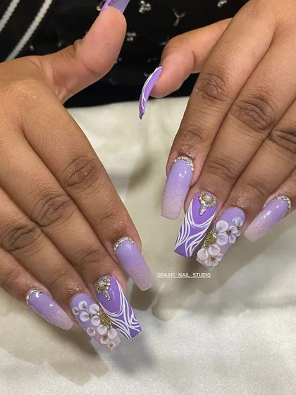 Festive bling for Diwali 2024. This elaborate set features long, coffin-shaped nails with a purple ombré, intricate white line work, 3D flowers, and plenty of crystals.