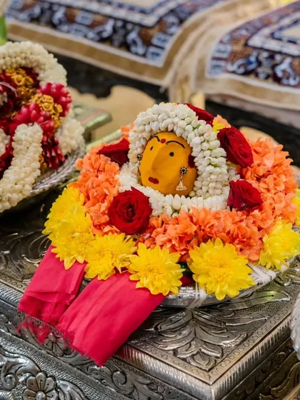A close-up of a deity decorated with fresh flowers for a traditional ceremony. This showcases my attention to the small, sacred details that are central to our cultural rituals.