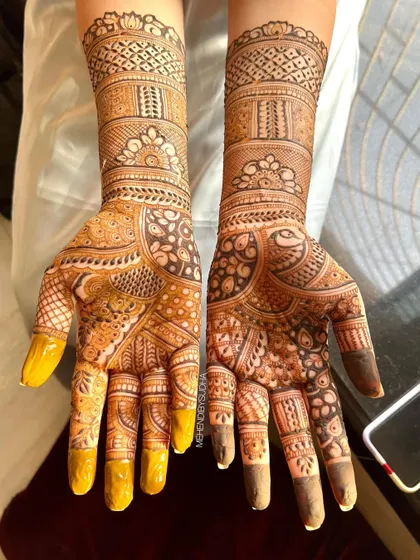 A beautiful bridal design with a mix of traditional Indian patterns, including paisleys and checks, showing a lovely two-tone stain.