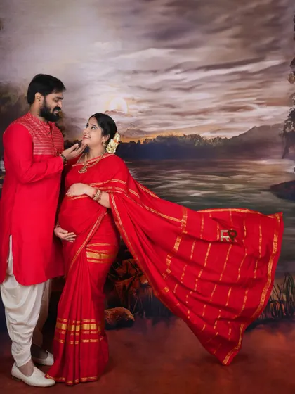 A romantic pose for our traditional shoot. The couple, coordinated in red, shares a loving gaze against the classic painted landscape, creating a storybook feel.