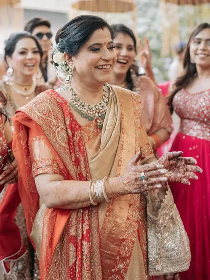 A beautiful, happy moment captured during the wedding festivities. The intricate work on her beige and gold saree shines as she celebrates.