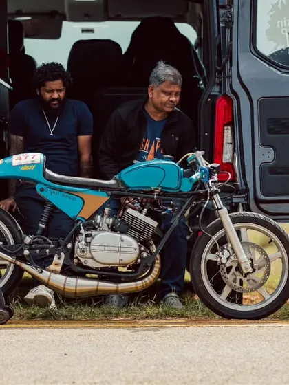 A custom cafe racer, a beautiful blend of vintage style and modern performance, sits ready for its run.