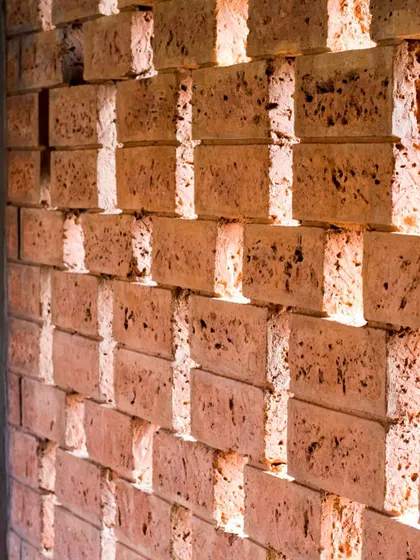 A close-up of a perforated brick wall, demonstrating our use of indigenous materials to enhance facade design. This technique, seen here at the Symbiosis University Hospital, allows for ventilation while creating a textured, rhythmic surface.