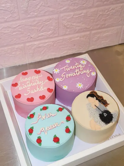 A dreamy set of four birthday bento cakes for a "twenty something" celebration. Each cake has a unique design, including a chic illustration, delicate roses, and sweet messages, all in a lovely pastel color palette.