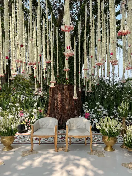 The seating for the bride and groom, perfectly positioned under a canopy of flowers hanging from the tree branches.
