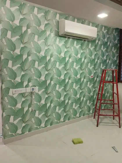 Another angle of the green leaf wallpaper installation, showing the room before furniture is added.