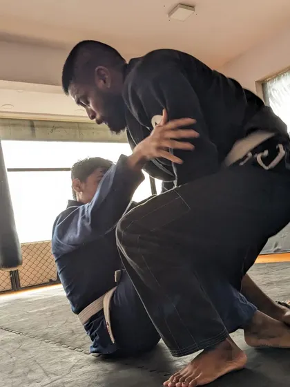 A student practicing a guard pass in the Gi. Our classes focus on these fundamental movements that are key to advancing your position.