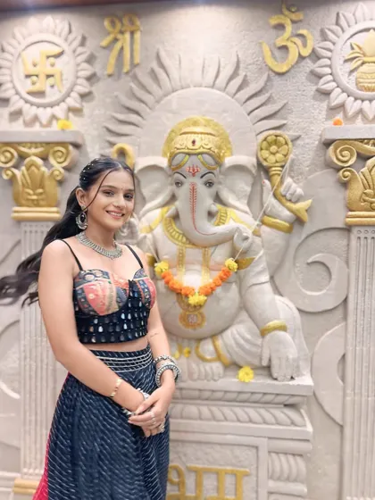 Another angle of this fun and festive Garba look. The high ponytail keeps the hair off the face for dancing, while the subtle makeup highlights her natural features beautifully.