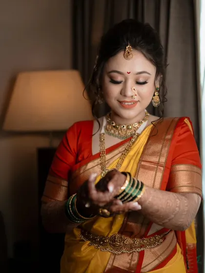 A beautiful close-up of the bride admiring her green glass bangles, a significant part of the Maharashtrian bridal look.