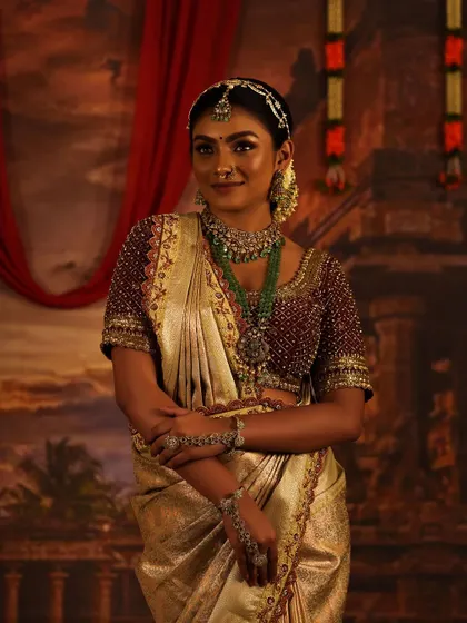 An ethereal look in an off-white tissue saree with a stunning maroon, fully beaded blouse.