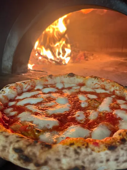 A classic Margherita, glowing in front of the fire. Simple perfection.