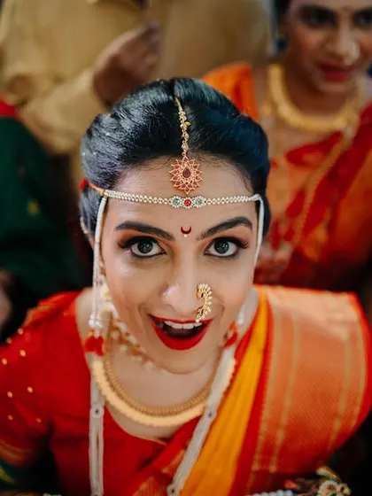 A direct, expressive shot of the bride looking up during the ceremony. Her wide-eyed, joyful expression is the centerpiece of this vibrant, candid moment.
