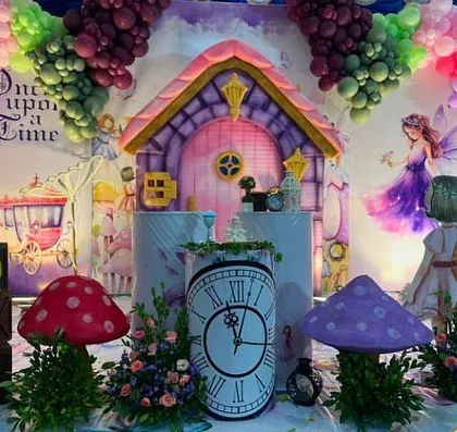 Welcome to 'Onderland'! This fairy house theme is full of whimsical details, including giant mushrooms, a clock plinth, and a storybook backdrop.