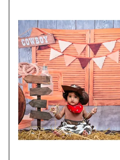 This little cowboy is sitting amidst hay and rustic signs. I use a variety of textures and props to add depth and interest to my themed photoshoots.