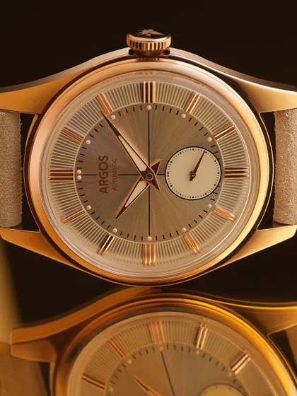 A classic hero shot. The Argos watch is presented with its reflection, creating a sense of elegance and balance. The lighting is carefully controlled to define the watch's shape and show off the sunray finish on the dial.