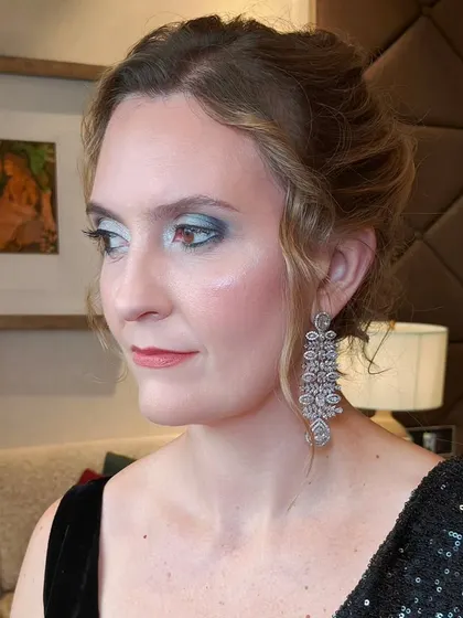 A side profile of this guest's evening look. The smokey eye is balanced with a soft lip color and a beautifully textured updo.