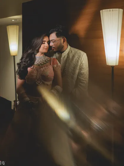 We use creative lighting techniques to add a touch of magic to our photos. This dreamy, artistic shot uses a prism flare to create a soft, romantic glow, perfectly suiting the intimate mood of this indoor couple portrait.