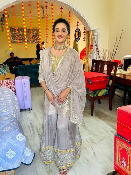 A full-length shot of the client in her elegant grey sharara suit. The makeup is sophisticated and age-appropriate.