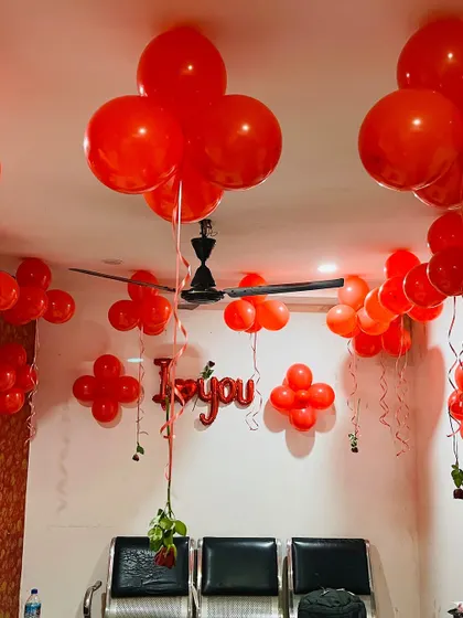 This image shows the balloon arrangement in the hotel room, with red balloon clusters on the ceiling and walls, complemented by 'I love you' foil letters.