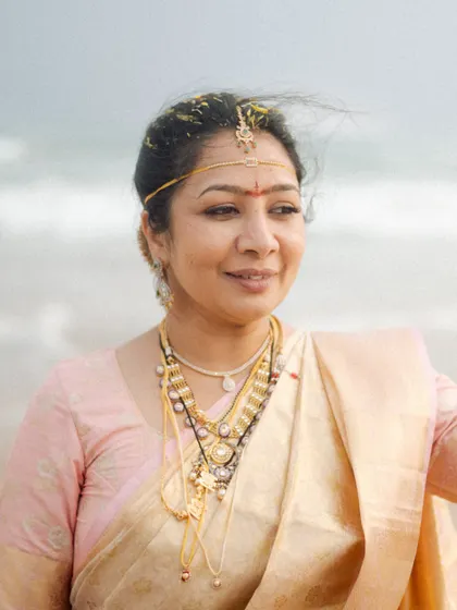 A bride on the beach, the wind gently blowing through her hair. This portrait captures a moment of peace and contentment against the backdrop of the sea.