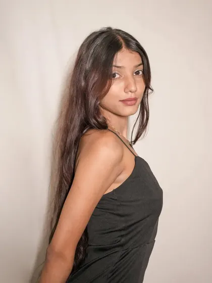 A classic portrait capturing the model's direct gaze and the simple, alluring style of the black dress.