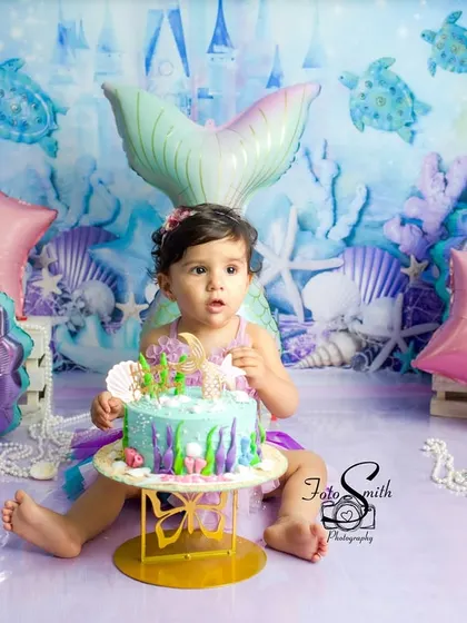 A beautiful portrait with a custom mermaid-themed cake. The details, from the cake to the backdrop, are all carefully planned to make your baby's first birthday shoot unforgettable.