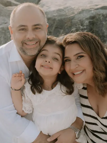 A beautiful family portrait. Mama bear, papa bear, and the big sister eagerly waiting to meet the newest addition to their family. Her makeup is natural and radiant for this beachside family shoot.