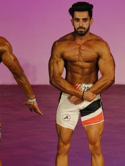 On stage at Musclemania, showcasing a classic pose. This is about creating an aesthetic and balanced physique.