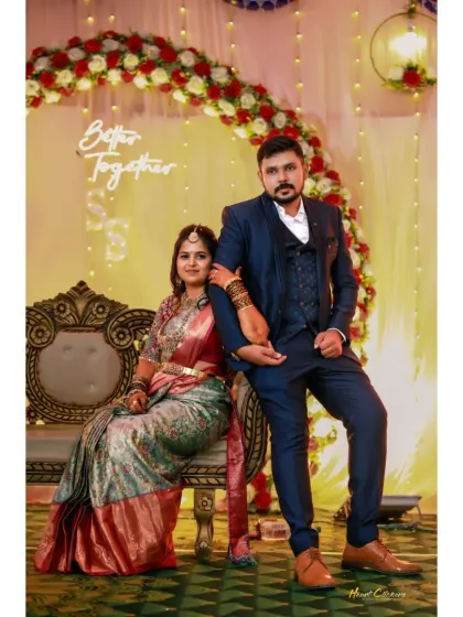 A regal portrait of the couple at their reception. The elegant seating and floral decor create a sophisticated and celebratory atmosphere.