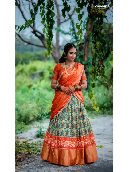 A full-length portrait of a bride-to-be in her beautiful engagement outfit, set against a natural, green background.