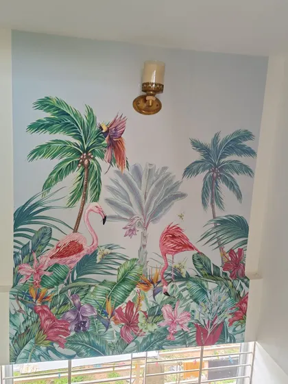 A vibrant tropical mural with flamingos and parrots, installed on a high staircase wall.