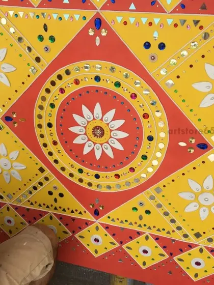 A close-up of a geometric pattern, showing the detailed mirror work within the floral and diamond shapes. This traditional style is known for its symmetry and sparkle, which we carefully recreate by hand.