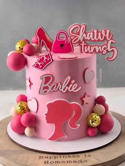 It's a Barbie party! This fun and funky pink cake is perfect for a 5th birthday, complete with disco balls, high heels, and the classic Barbie logo.