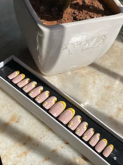 The sunflower press-on nail set in its packaging, ready to be gifted or worn. I can customize the length and shape, from short and round to long and almond.