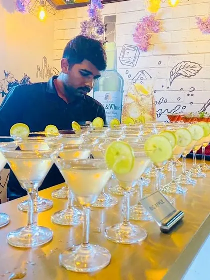 A tray of classic martinis, perfectly chilled and garnished with a lime wheel. We pride ourselves on our meticulous attention to detail, ensuring every drink is prepared and presented beautifully for your guests.